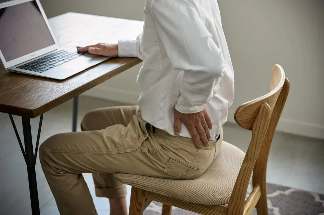 A modern office setup with an ergonomic chair and an orthopedic cushion on a desk chair, highlighting posture support options.